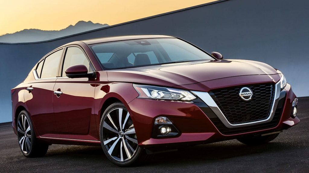 Stylish red Nissan sedan parked against a scenic backdrop