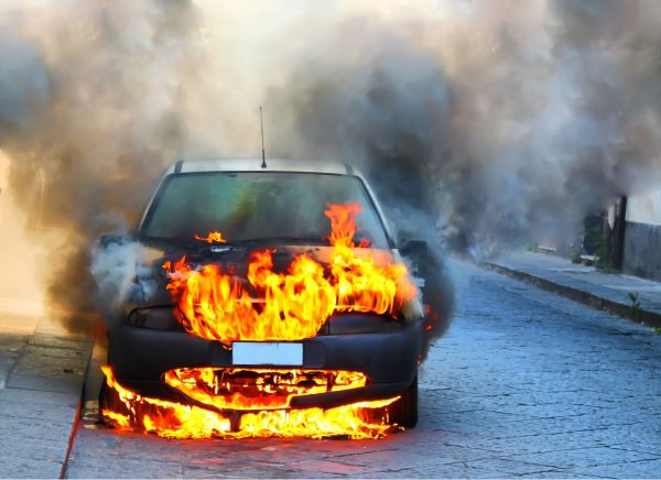 Car engulfed in flames on a street