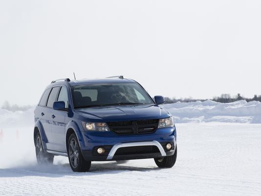 Blue SUV driving on snowy terrain in winter