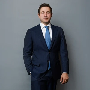 Businessman in a formal suit against a gray backdrop