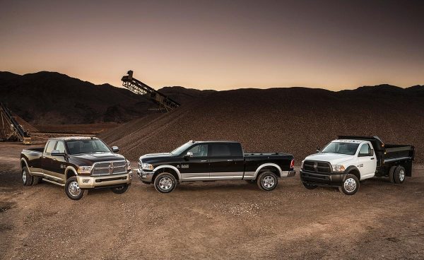 Three trucks positioned in a mining site at sunset