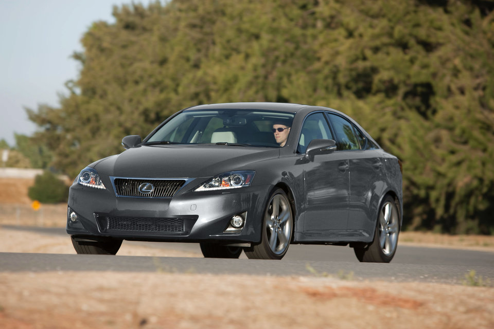 Gray Lexus IS sedan driving on a sunny road
