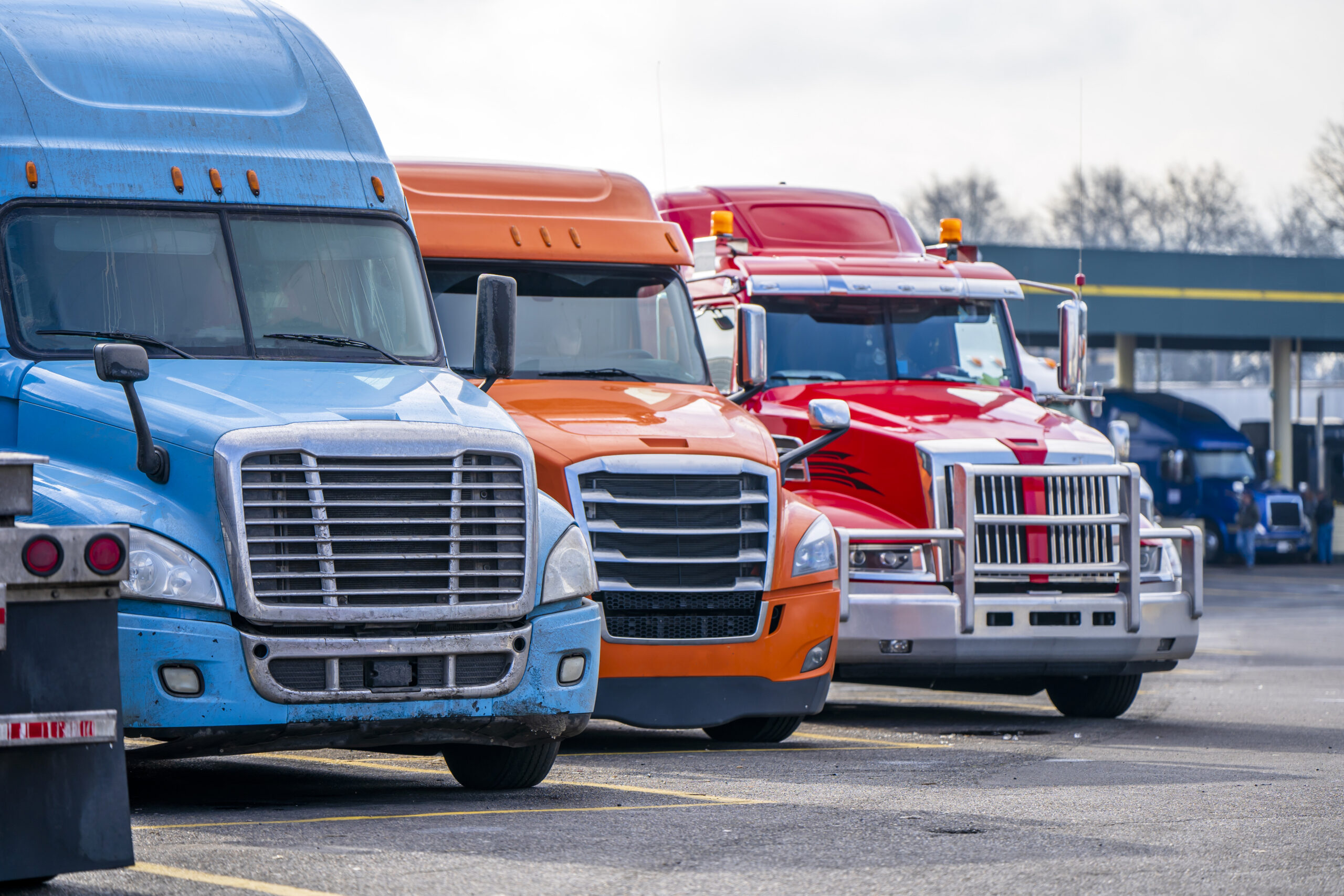 Brightly colored semi truck cabs line up in a yard, illustrating underride accident risks, rear-guard failures, and truck manufacturer liability.
